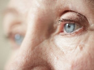 An elderly woman sadly looking out of the window. Care facilities are still accountable for giving residents proper care during COVID-19 restrictions.