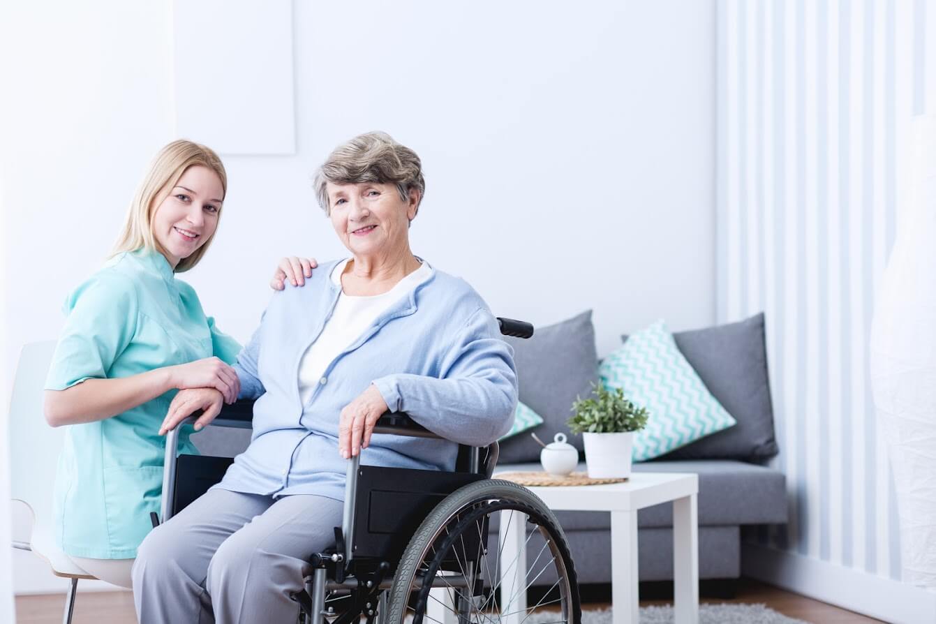 A woman visiting an elderly woman in a nursing home. No signs of nursing home neglect. Learn what to do if neglect occurs.